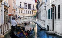 A gondola carries tourists along the Venice canals, Italy. 