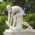 marble statue of a naked man bending down